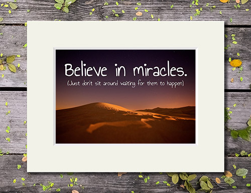 Sand dunes at night with 'Believe In Miracles (Just Don't Sit Around Waiting For Them To Happen)' quote