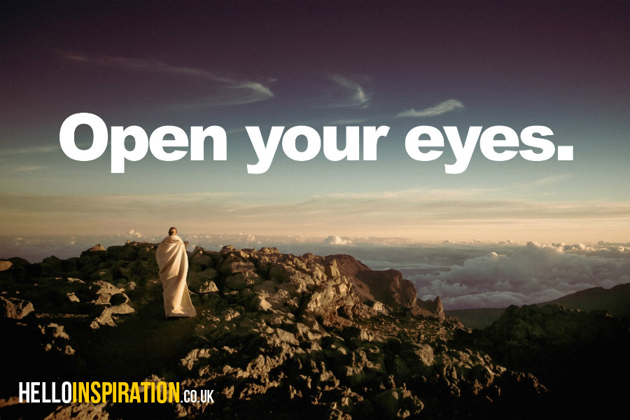 Lone figure in white on a mountain top with 'Open Your Eyes' quote