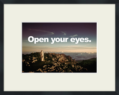 Lone figure in white on a mountain top with 'Open Your Eyes' quote