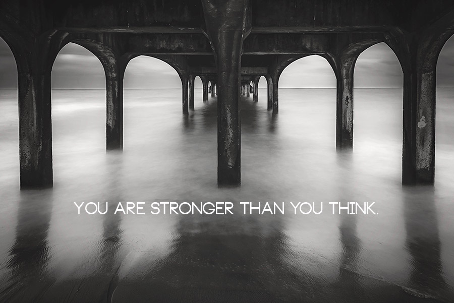 Moody long exposure black and white image of a pier with 'You Are Stronger Than You Think' quote